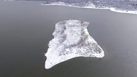 Aerial drone pull back shot of snowy island on mcphee lake near dolores colorado Stock Footage 256614394