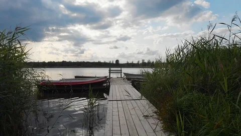 Aerial drone pull up shot camera flies high from a boat berth dock toward a lake Stock Footage 114035190