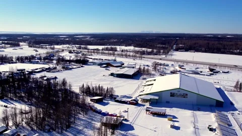 Aerial drone pullback and orbit of Alaska State Fairgrounds livestock building Stock Footage 332185528