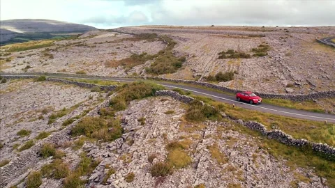 Aerial Drone Pullback Over Burren Roads and Limestone with Red Car, Ireland Stock Footage 301410906