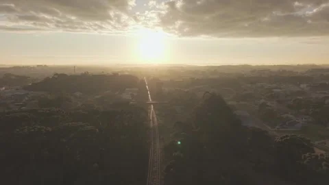 Aerial drone pullback over railway with road bridge and sunrise in background Vídeos de archivo 333385181