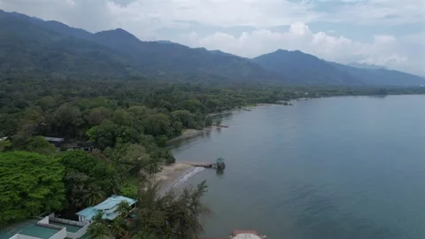 Aerial Drone Pullback Over Tropical Beach Resort with Green Mountain, Ocean and Video stock 336094265