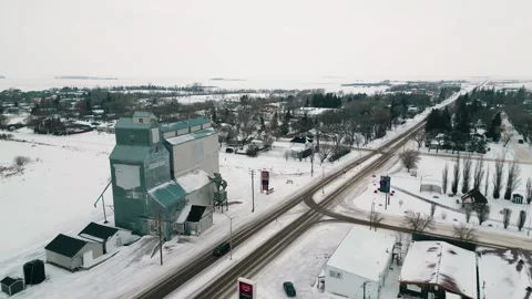 Aerial drone pullback revealing grain elevator and distant rural roadway Stock Footage 296626436