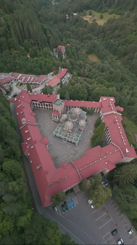 Aerial drone pullback revealing Rila Monastery surrounded by forest in Bulgaria. 스톡 동영상 343418632