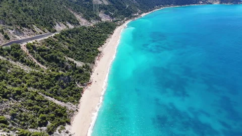 Aerial drone pullback revealing a stunning turquoise beach, winding coastal Vídeos de archivo 337202514