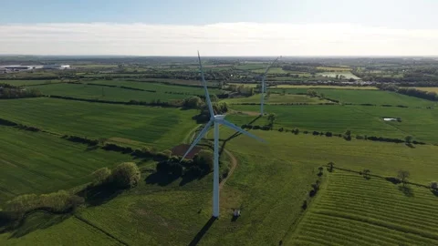 Aerial drone pullback revealing wind turbines over countryside fields Stock Footage 333935984