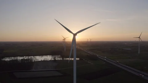 Aerial drone pullback shot from windmill blocking the sunset Stock Footage 127054492