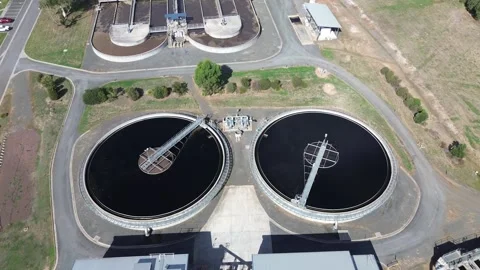 Aerial drone push forward over circular water treatment tanks Stock Footage 332750019