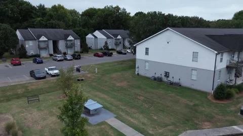 Aerial drone push over park pavilion toward apartment community Stock Footage 346731930