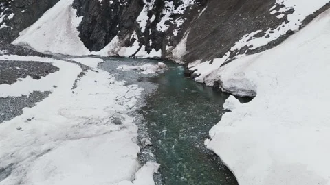 Aerial Drone Reveal of Avalanche Debris and Glacial River Stock Footage 332297953