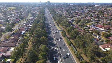 Aerial drone reverse view above the South Western M5 Motorway at Casula, NSW Video stock 244515369