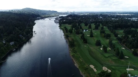 Aerial drone of river on a cloudy day with greenery and trees and a golf course Stock Footage 104820853