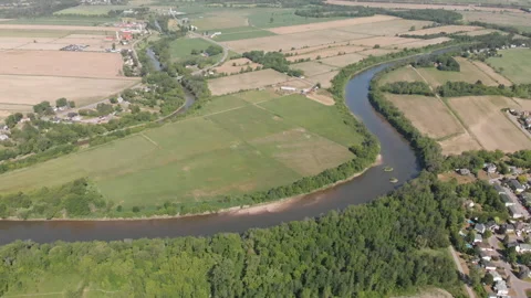 Aerial drone river tilt down suburban waste treatment facility town Stock Footage 169389796