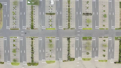 Aerial drone, road and empty parking lot in city for driving, stop signs and Stock Footage 258640026