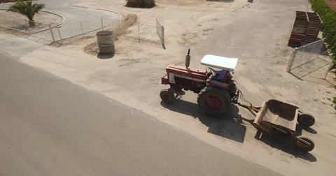 Aerial drone rotating tractor moving dirt driving farm Stock-Footage 67329026
