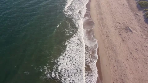 Aerial drone of sandy beach with waves gently lapping on shore Stock-Footage 323332830