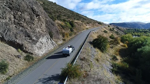 Aerial drone scene of the road and a van tracking and carring a trailer 스톡 동영상 89555853