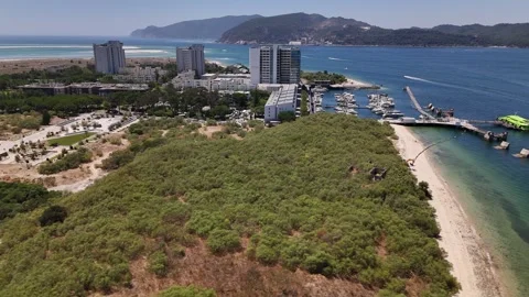 Aerial drone scenic orbit showcasing Troia's coastline with modern buildings Stock Footage 314119251
