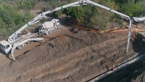 Aerial drone shot above constructions site outdoor. Big white crane pouring Stock Footage 131015424