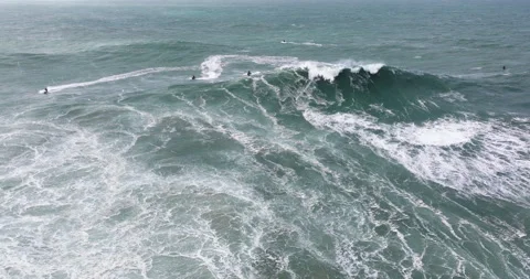 Aerial drone shot of big wave surfer surfing a giant wave and celebrating in Stock Footage 321353103