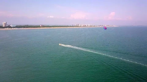 Aerial drone shot of boat pulling parachute over the sea in lignano parasailing Stock-Footage 233644193