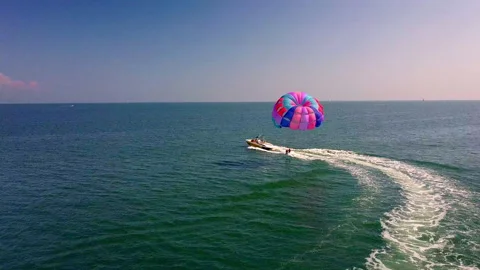 Aerial drone shot of boat pulling parachute over the sea in lignano parasailing 스톡 동영상 233645286