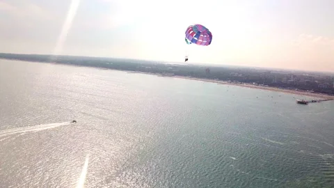 Aerial drone shot of boat pulling parachute over the sea in lignano parasailing Stock Footage 233646818