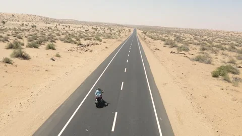 Aerial drone shot capturing the adventurous spirit of a biker traversing the Stock Footage 310749701