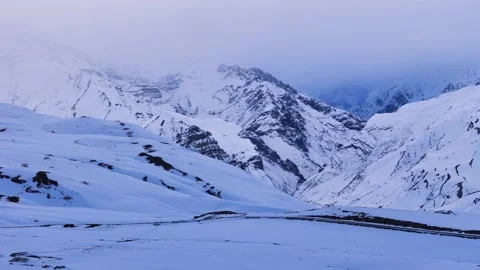 Aerial drone shot capturing the breathtaking view of snow-covered mountains in Stock Footage 304944032