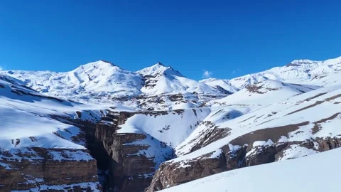 Aerial drone shot capturing the breathtaking view of snow-covered mountains in Stock Footage 304951706