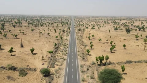 Aerial drone shot capturing a lone vehicle moving along an empty highway Stock Footage 310748680