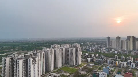 Aerial drone shot capturing the Noida skyline bathed in warm hues during sunset. Stock Footage 312490633