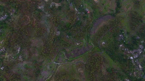 Aerial drone shot capturing a small village nestled in the heart of towering Stock Footage 310748347