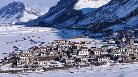 Aerial drone shot capturing the snow-clad Kaza city, where the sunlight enhances Stock Footage 304944531
