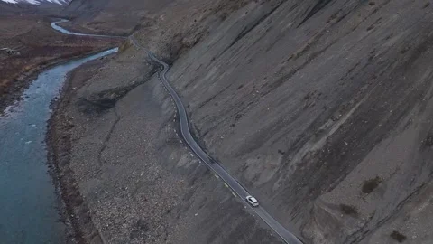 Aerial drone shot capturing a stunning high-altitude road trip, as a white car Stock Footage 304950705