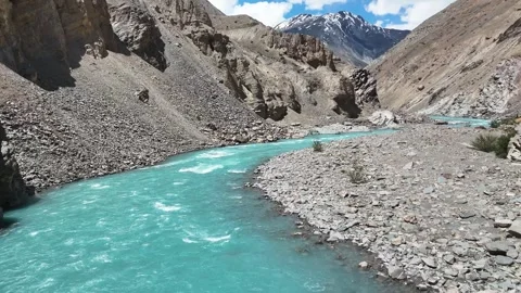 Aerial drone shot capturing turquoise river waters flowing past a historic Stock Footage 310752357