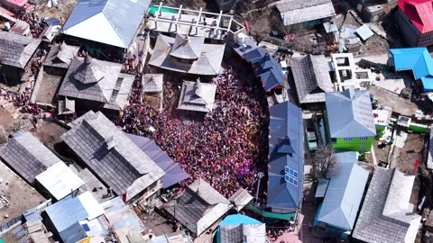 Aerial drone shot capturing the vibrant celebration of Holi at Sangla Mandir, as Stock Footage 304947598