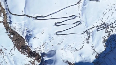 Aerial drone shot capturing a winding mountain road in Spiti, partially covered Stock-Footage 304952230