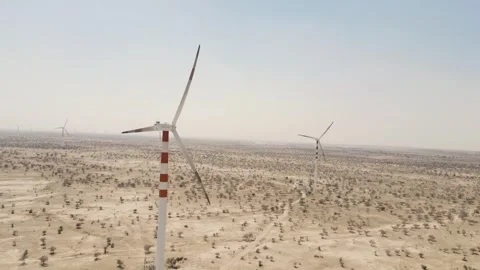 Aerial drone shot capturing windmills standing tall across the sandy landscape Stock Footage 310749731