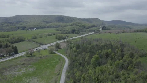 Aerial Drone Shot of Car on Road in Scenic Rural Farmland Stock Footage