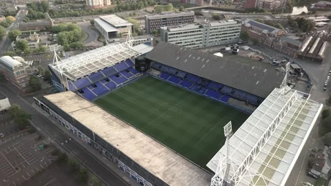 Aerial Drone Shot Circling Empty Football Stadium with Blue Seats in Urban Stock Footage 339983792