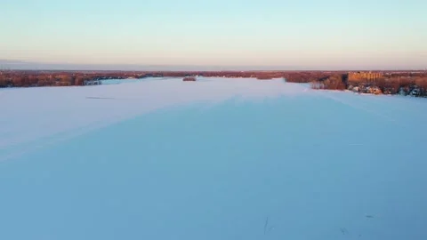 Aerial drone shot coming down and moving back slowly over the frozen river Video stock 163979502