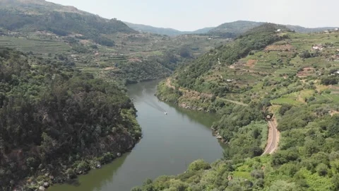 Aerial, drone shot of the Douro River with a motorboat surrounded by mountains Stock Footage 345109060