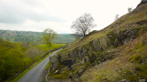Aerial drone shot down a road in the Lake District Stock Footage 59864692