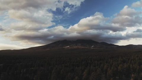 Aerial drone shot of dramatic clouds clustered around mountains over forest Stock Footage 127267591