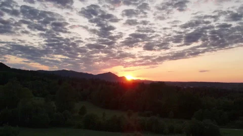 Aerial drone shot of dramatic sky during sunset over beautiful calm mountains Stock Footage 245476097