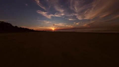 Aerial drone shot of a dramatic sunset over an empty beach with vibrant colors Vidéo 282757602