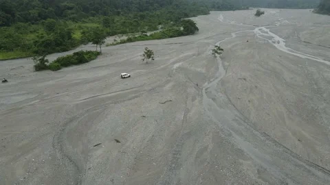 Aerial drone shot of a dried river during drought. Cars driving on a dried up Stock Footage 219335873