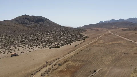 Aerial Drone Shot of dry empty spanish desert with vegetation and mountains in Stock Footage 119351368