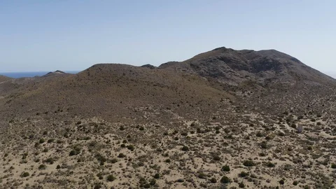 Aerial Drone Shot of dry empty spanish desert with vegetation and mountains in 動画素材 119351378